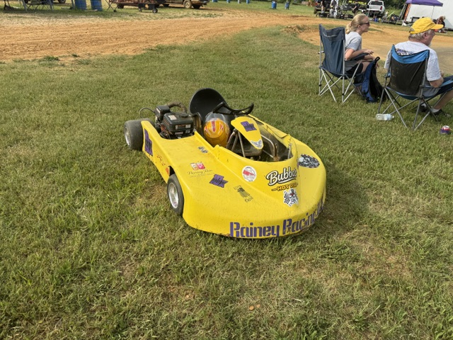 The yellow 10X sitting on the grass with the helmet resting in the seat
