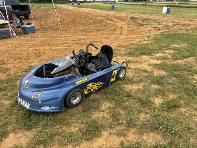 Ronnie's blue and yellow No. 3 kart parked in the pit area, full side view