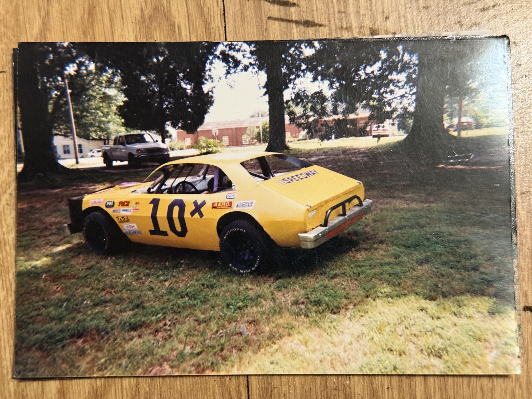 Ronnie Rainey Sr.'s bright yellow Mini Stock dirt car with bold purple 10X numbers on the quarter panel, parked in the yard in the early 2000s