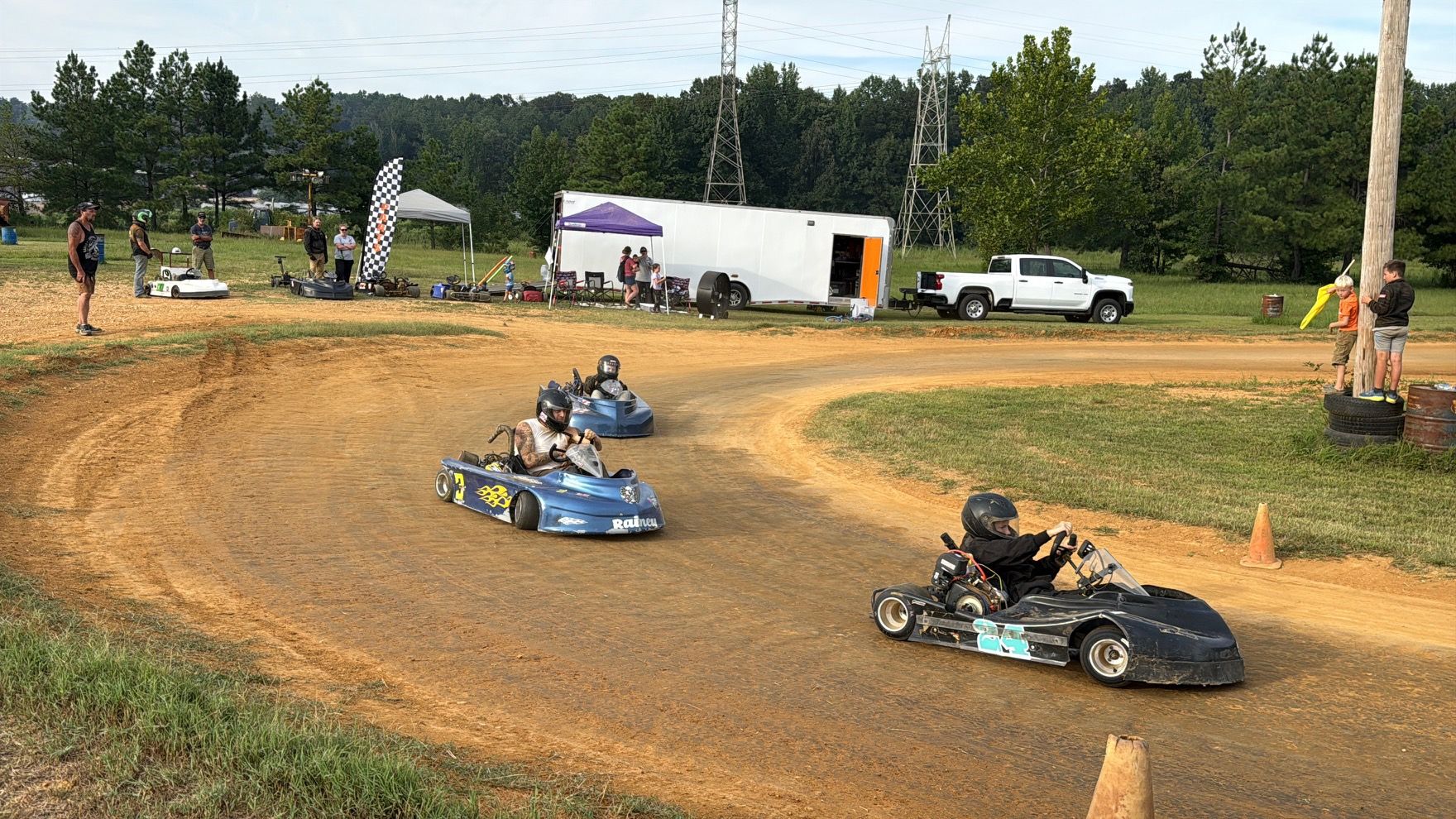 Ronnie Rainey racing the blue 3 kart alongside another kart at Camden Speedway