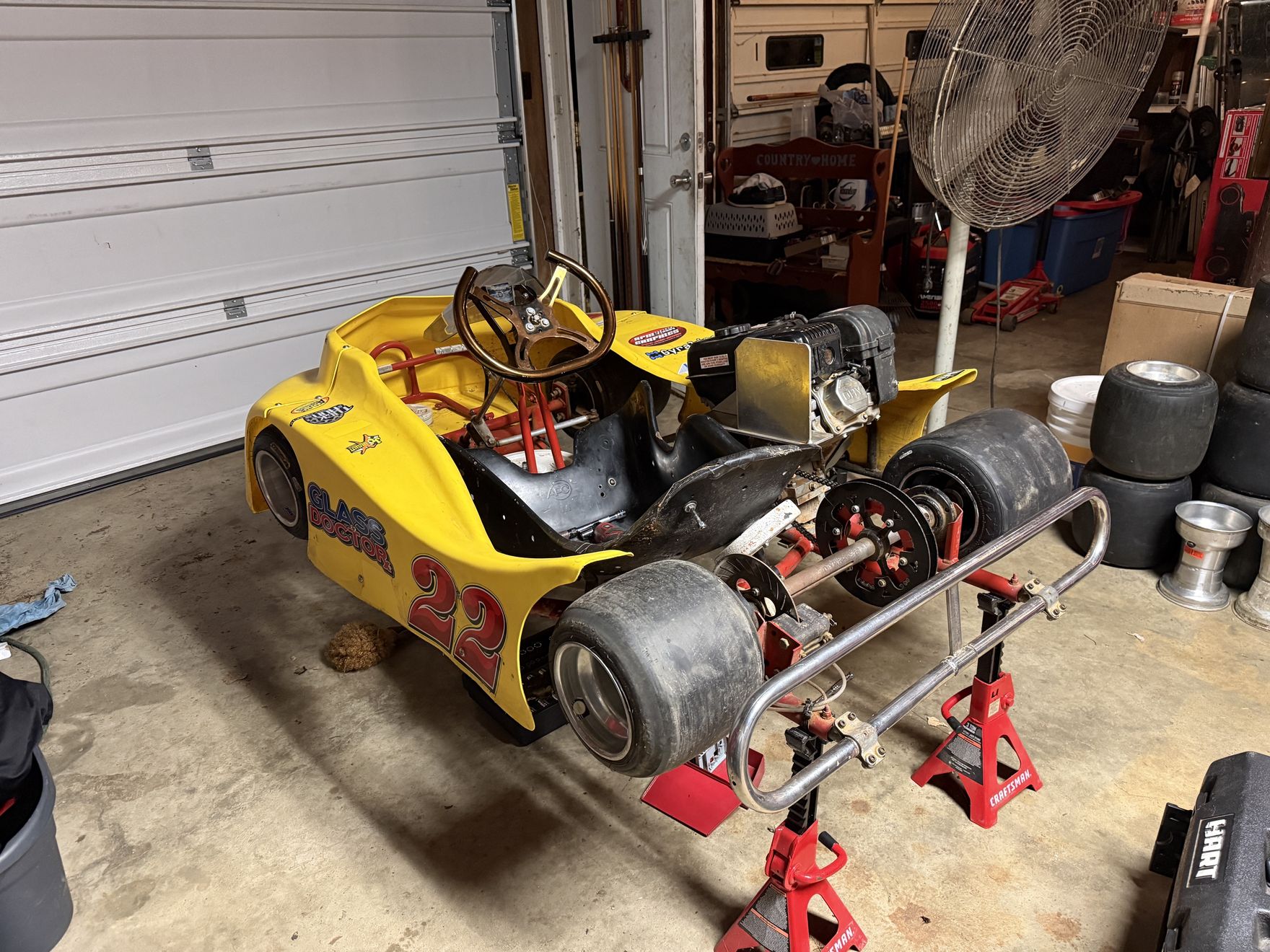 The new yellow #14 Phantom kart up on stands in the shop