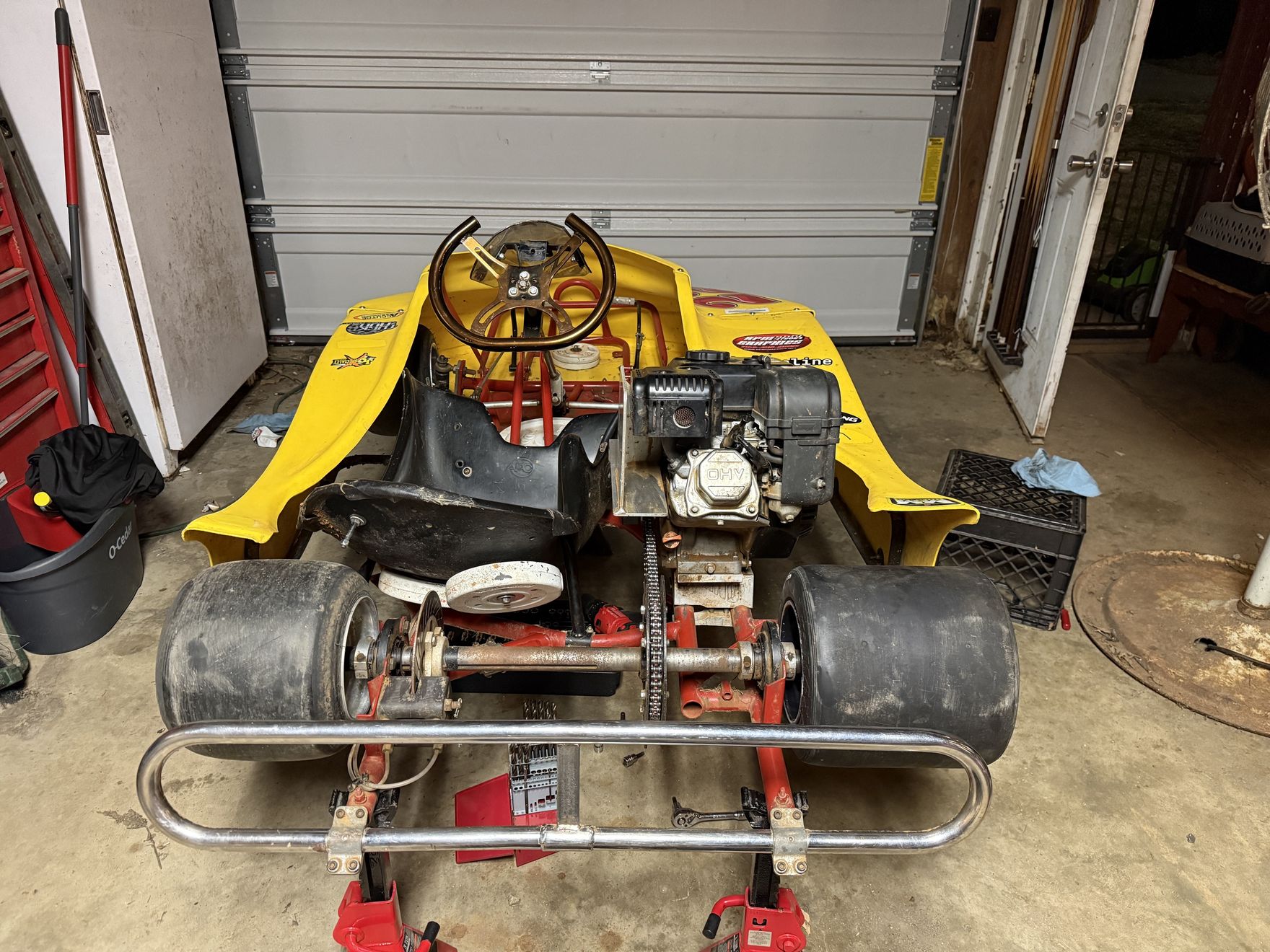 Front view of the new yellow Phantom kart up on stands in the garage