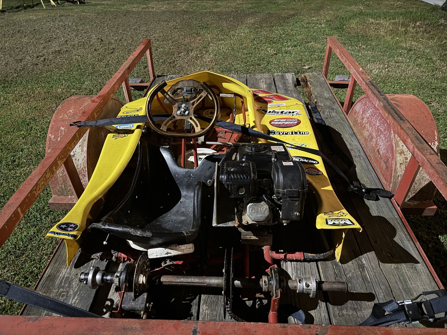 Rear view of the new kart strapped down on the trailer, motor and axle in view