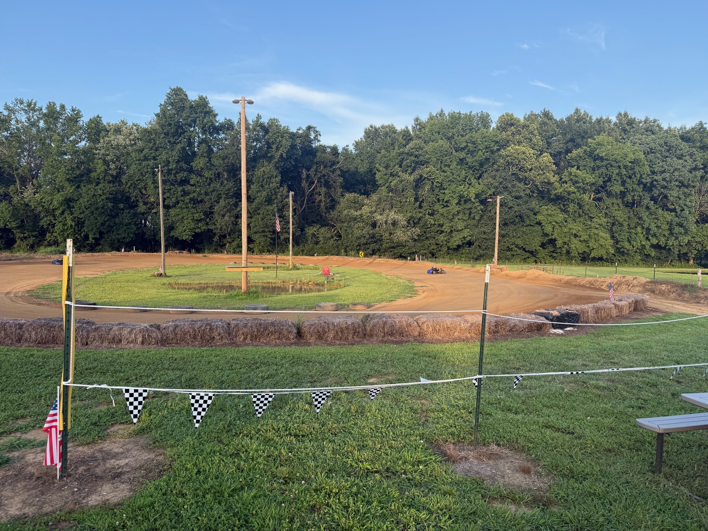 Wide view of the well-prepped Adjoining Hearts Raceway dirt oval in Woodlawn, TN under a blue sky