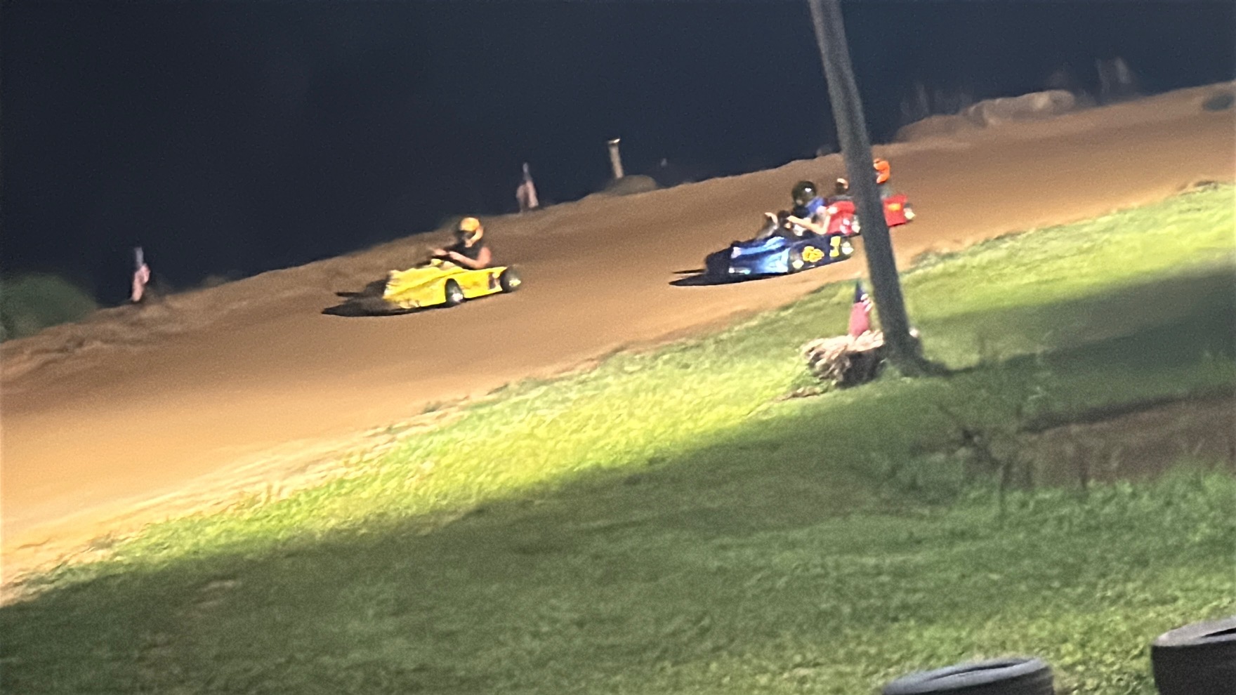 Travis's yellow 10X leading a blue and a red kart at night at Adjoining Hearts Raceway