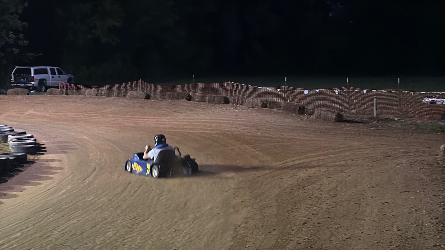 Ronnie's blue 3 sliding through the corner at night at Sleepy Hollow Speedway, throwing dirt