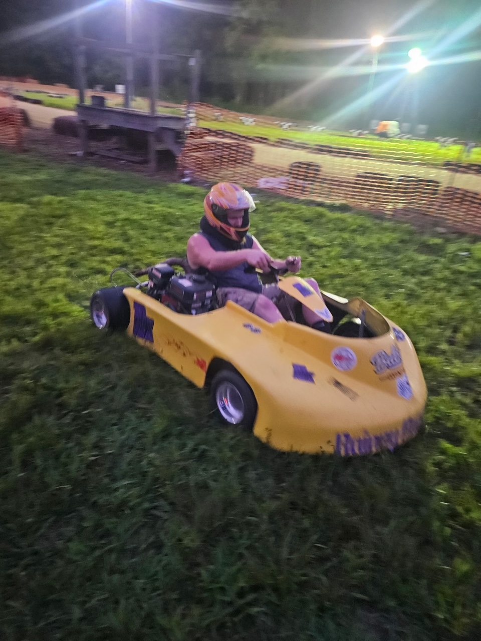 Travis at the wheel of the yellow 10X kart under the lights at Sleepy Hollow Speedway