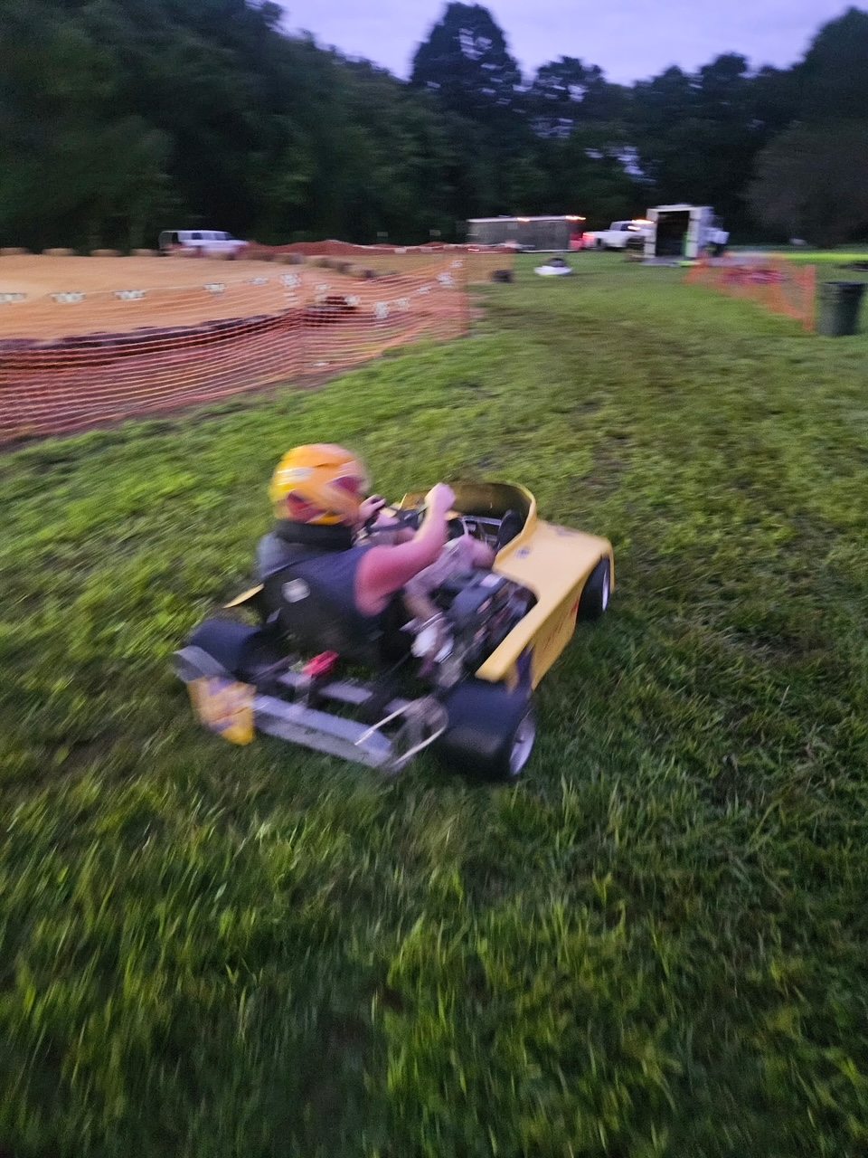 Travis at speed in the yellow 10X kart at dusk at Sleepy Hollow Speedway