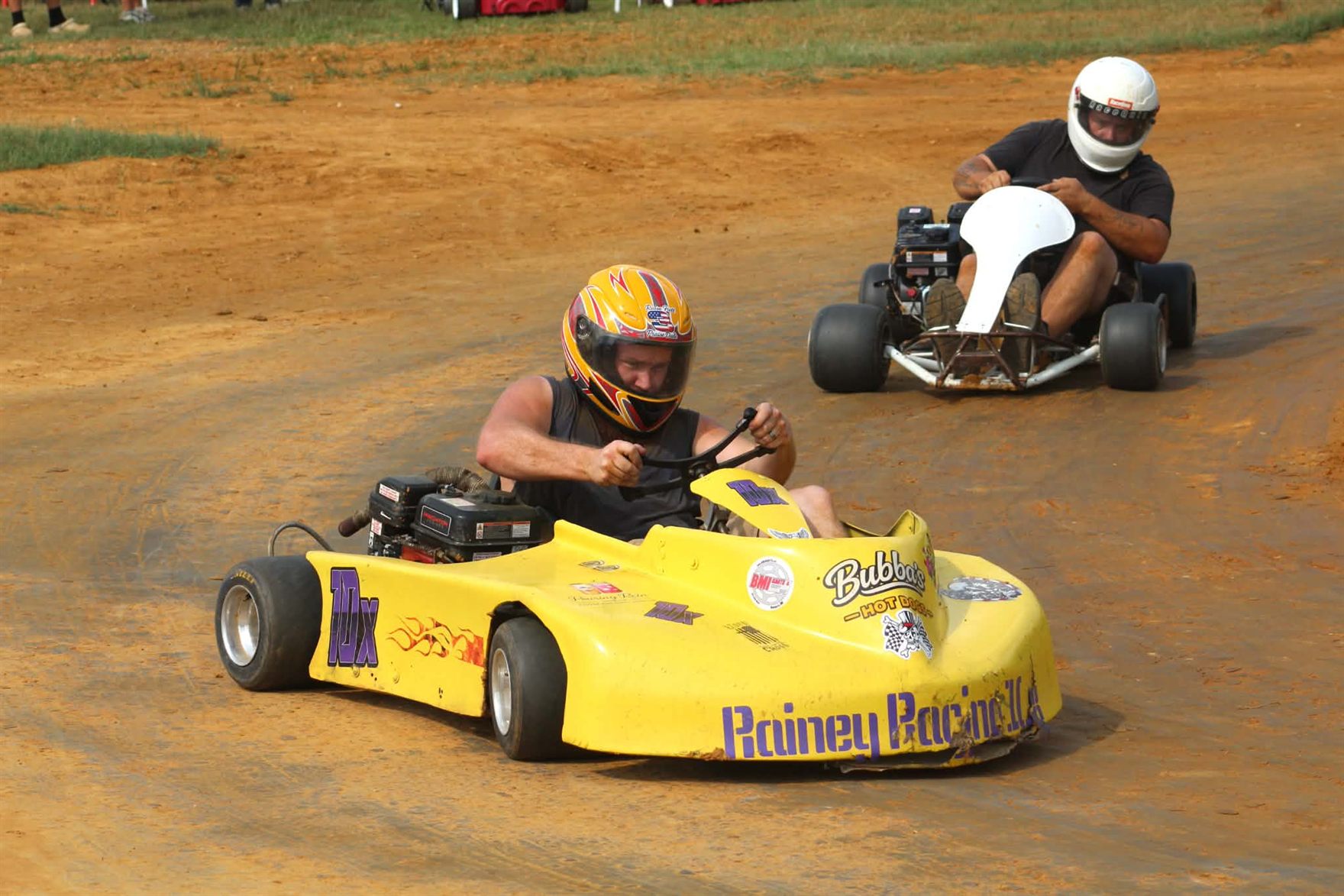 Travis's yellow and purple 10X kart leading another kart through the corner at Camden Speedway