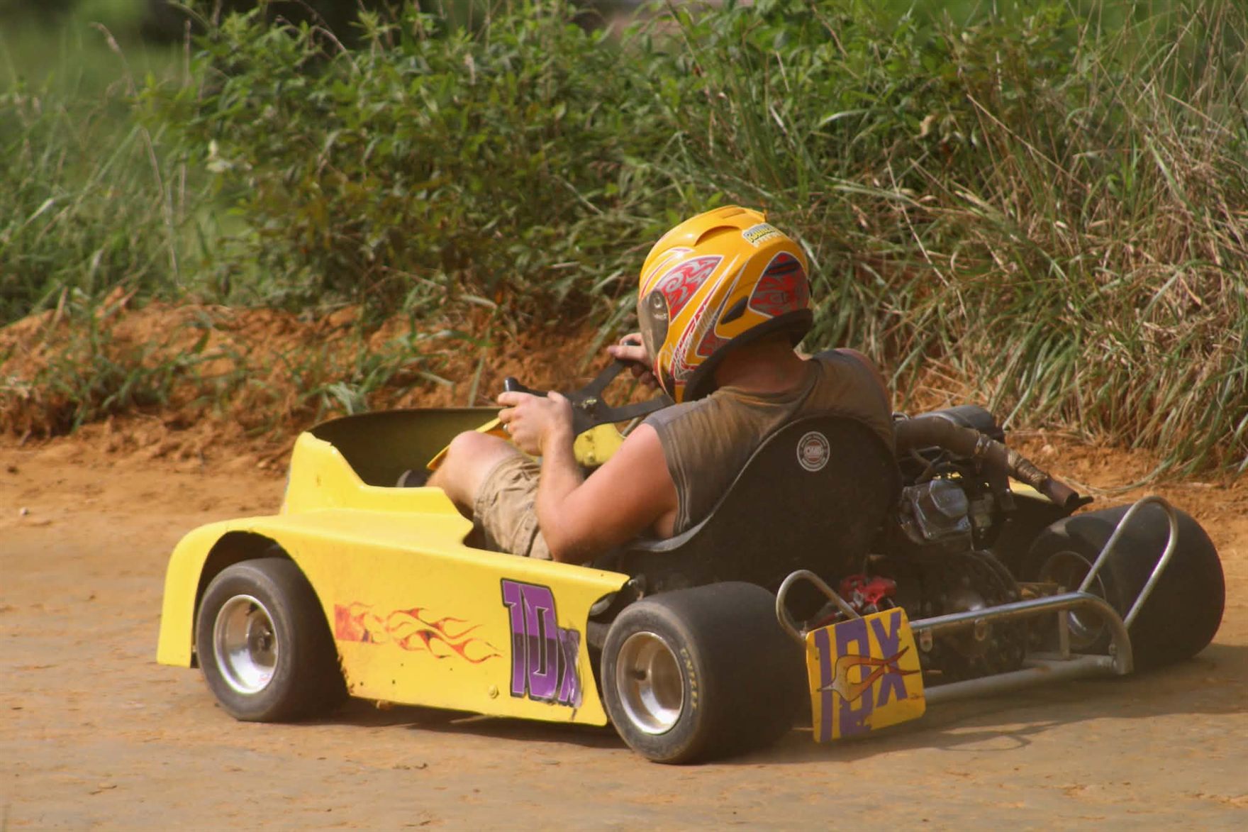 Travis's yellow 10X kart from behind, running the edge of the Camden Speedway dirt
