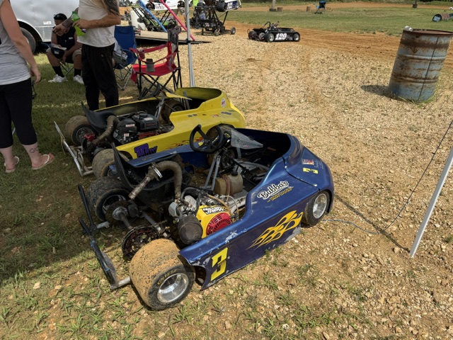 Both karts with their bodies off, showing the frames and engines in the pits