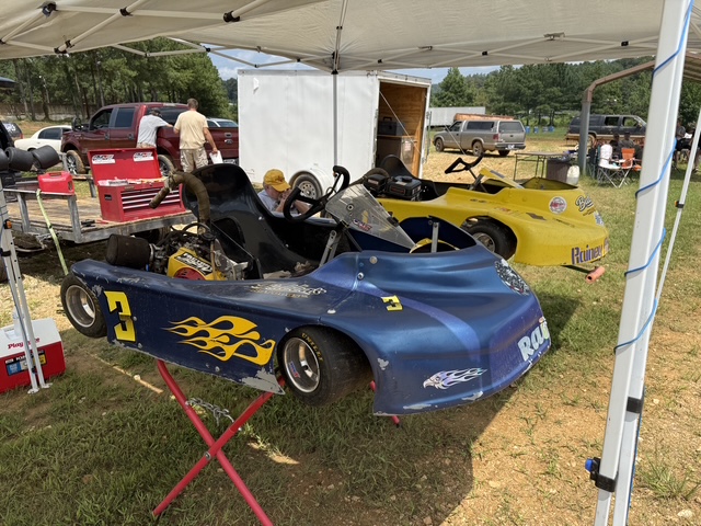 Both Rainey Racing karts parked under the team's pop-up canopy in the pits